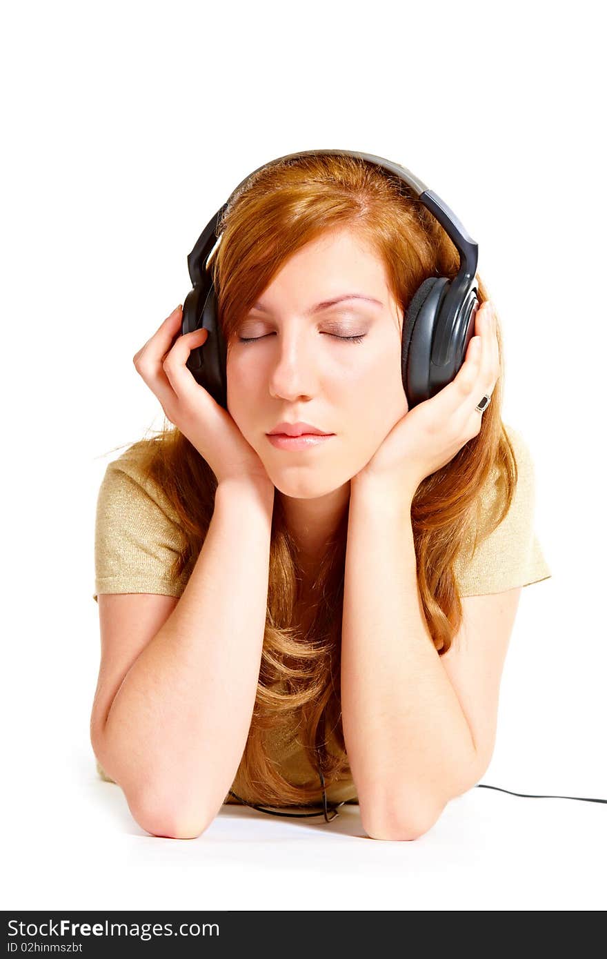 Girl with headphones laying isolated over white background