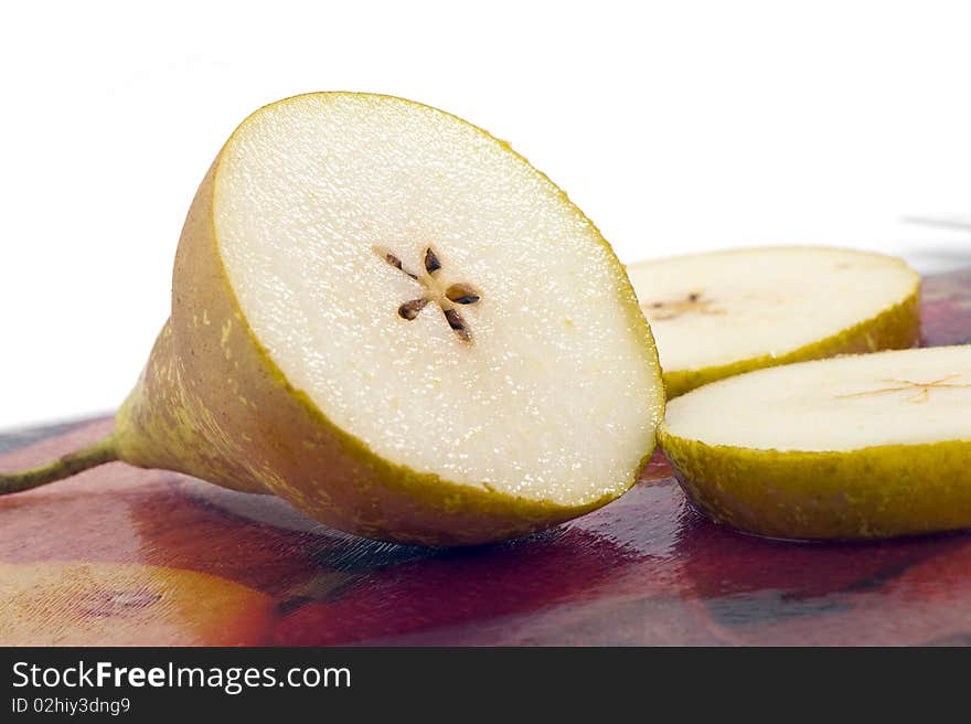 Half of pear on a glass cutting board studio shot