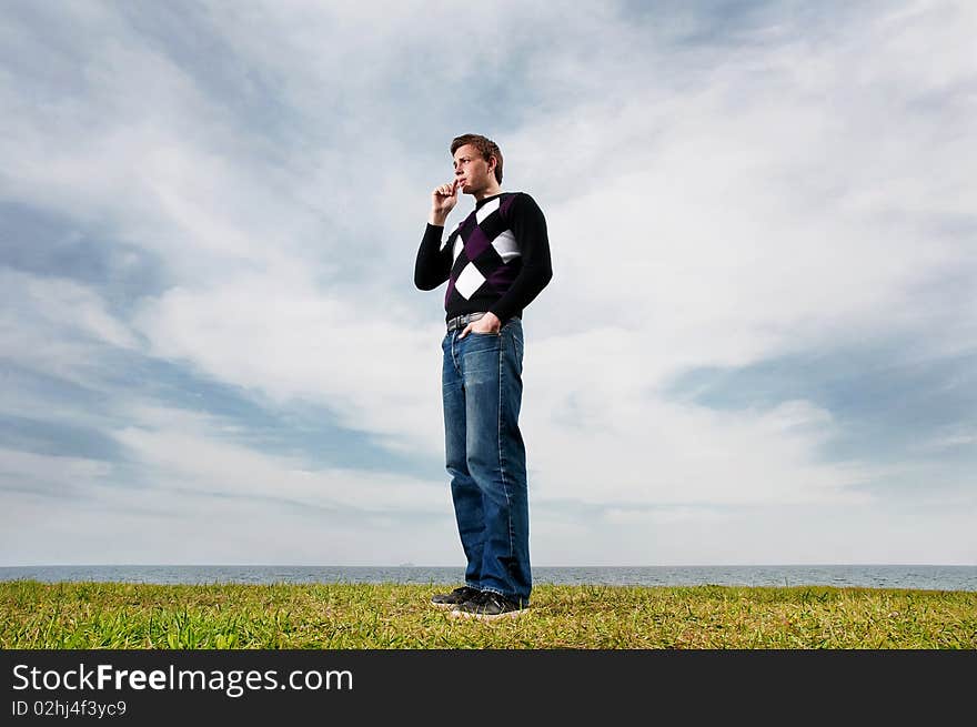 Young Man In The Clouds On The Green Grass