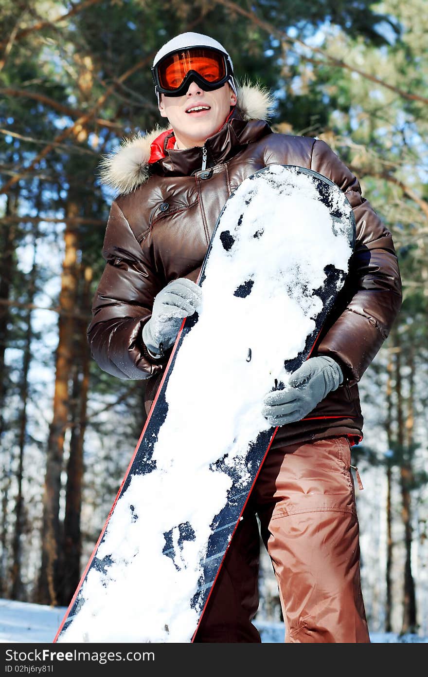 Shot of a handsome young man with a snowboard outdoor. Shot of a handsome young man with a snowboard outdoor.