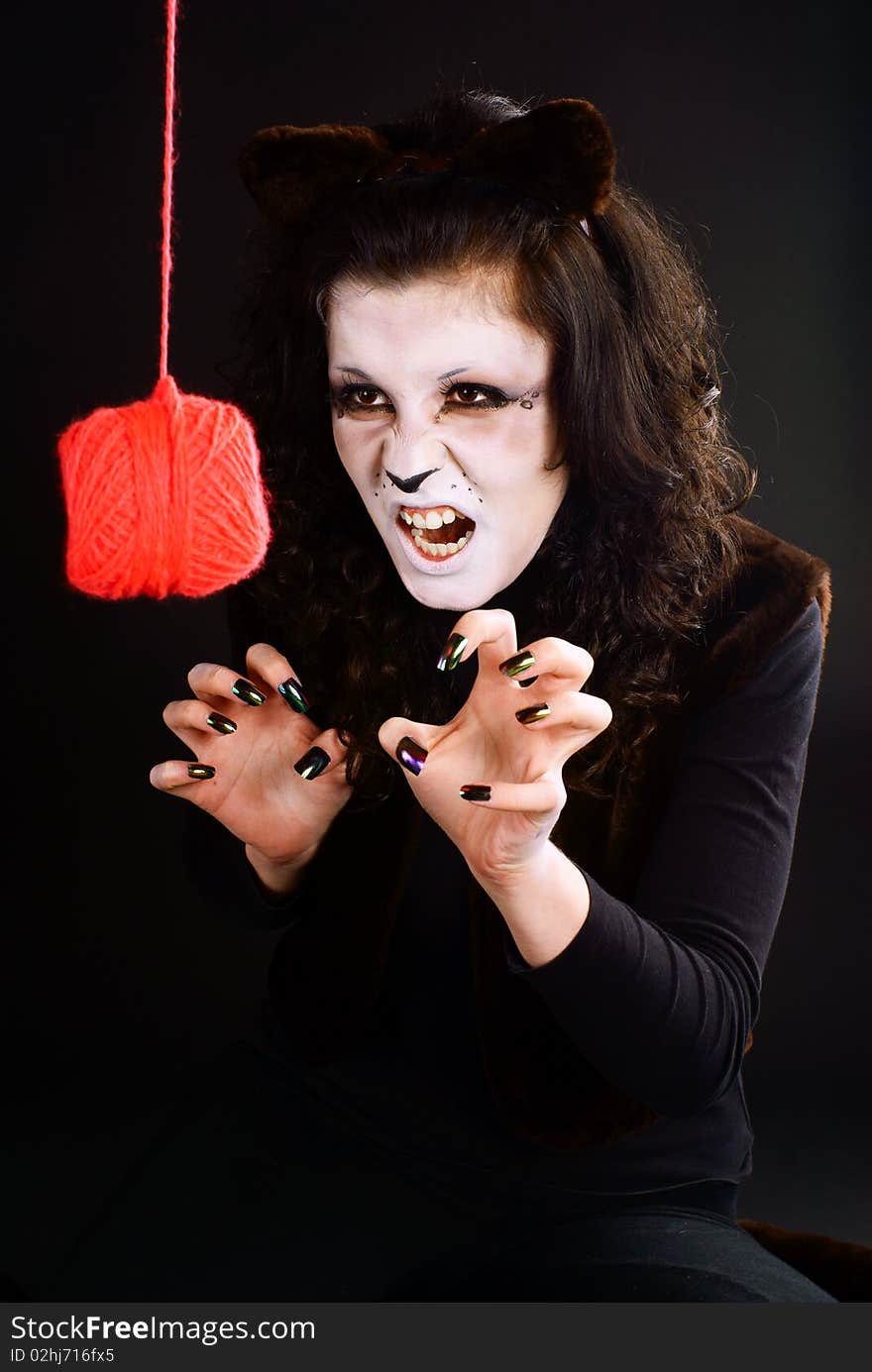 Cat-girl playing with a threads ball. Studio shot. Cat-girl playing with a threads ball. Studio shot.