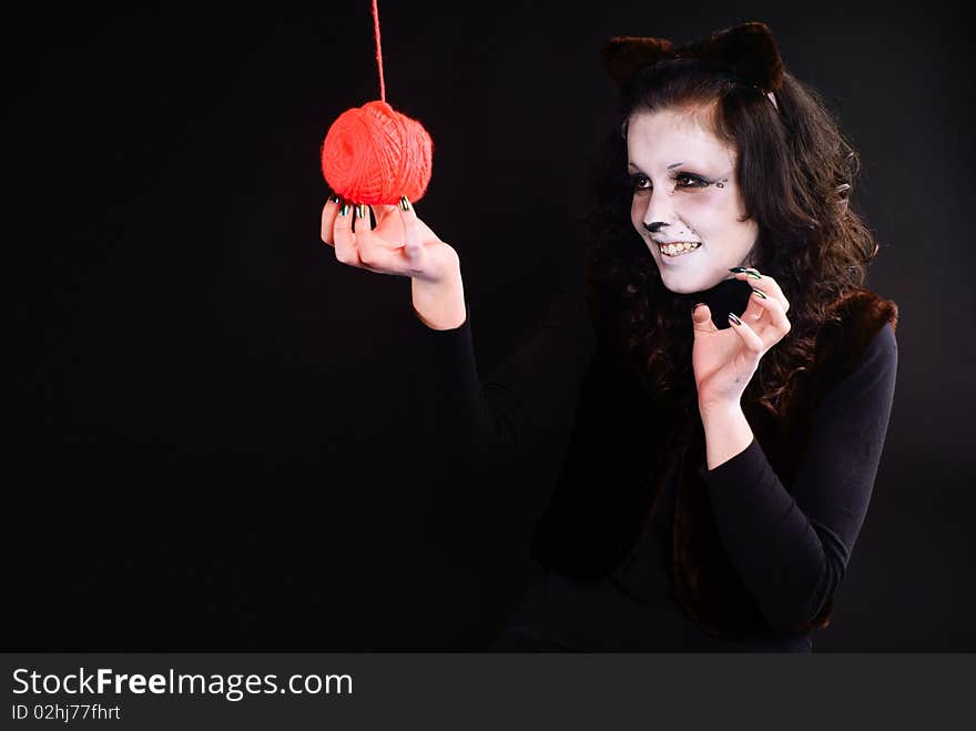 Cat-girl playing with threads ball. Studio shot. Cat-girl playing with threads ball. Studio shot.