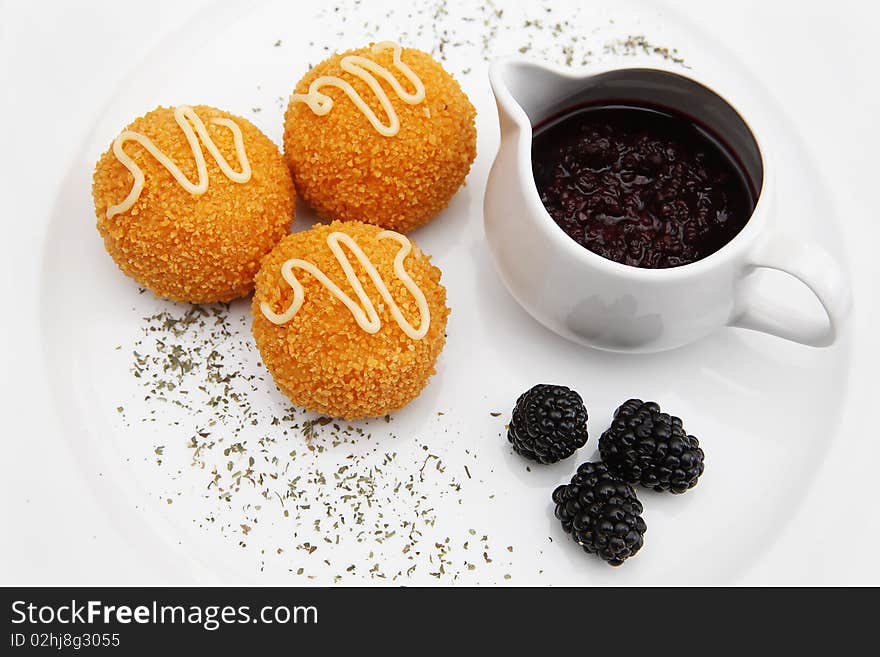 Cheese balls on the plate with jam and blackberry.