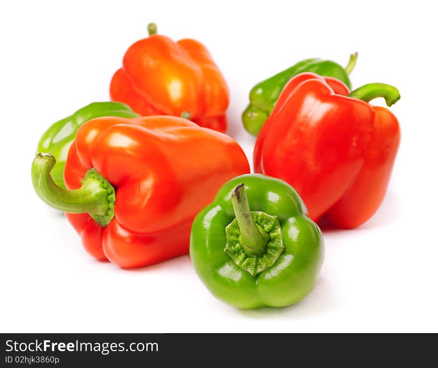 Red and green peppers on white