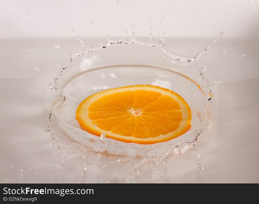 Orange slice under flowing water - concept of refreshment