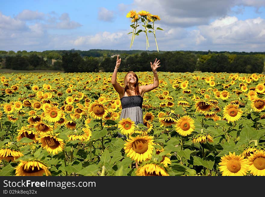 A young happy woman in a field of sunflowers. A young happy woman in a field of sunflowers