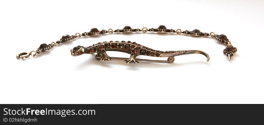 Jewelery - lizard figurine made of metal with natural grenades, isolation