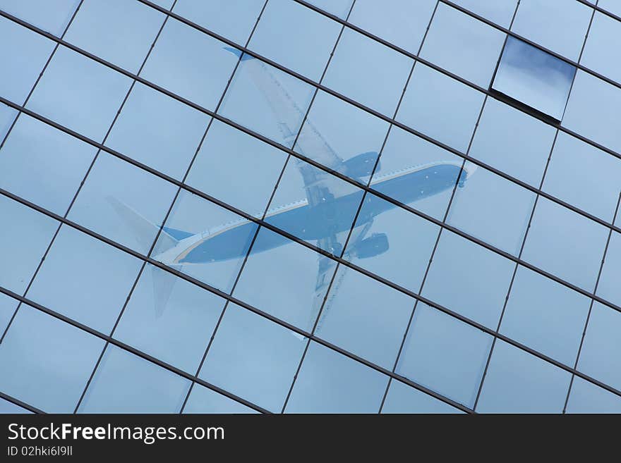 Building with a glass pattern with an airplane reflected