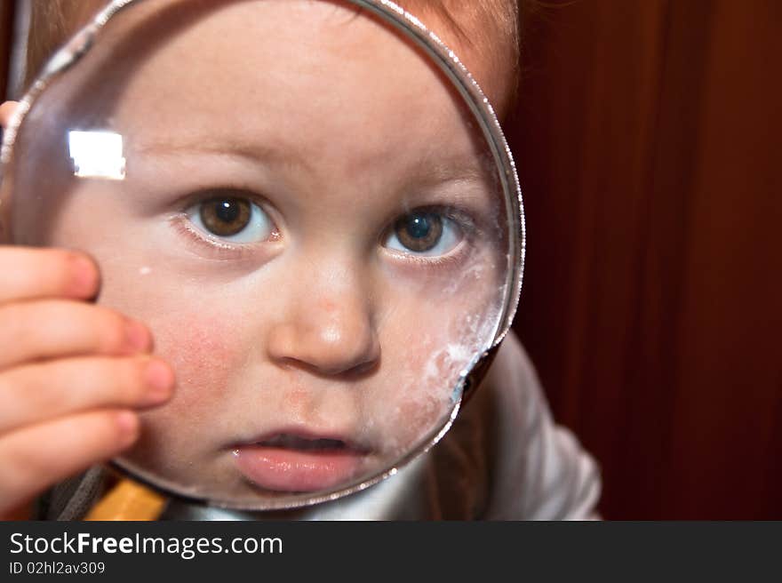 Young baby boy and magnifying glass