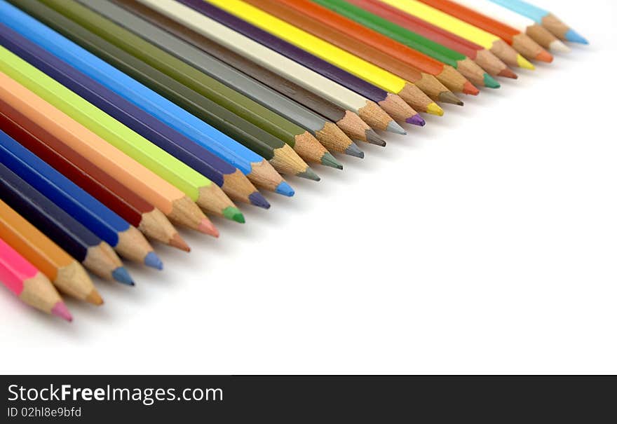 Pencils of various colors in diagonal on a white background