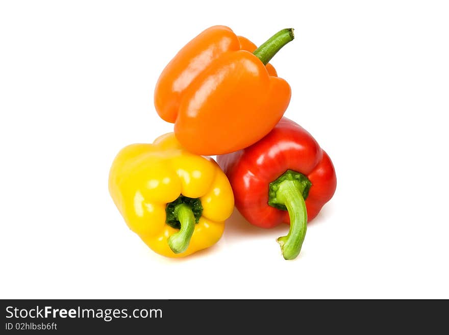 Red, yellow and orange bell peppers isolated on white.