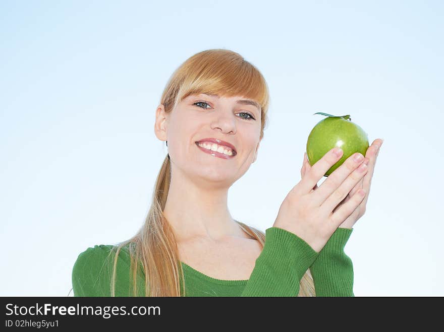 Green apple in a hand on a background of the sky. Green apple in a hand on a background of the sky