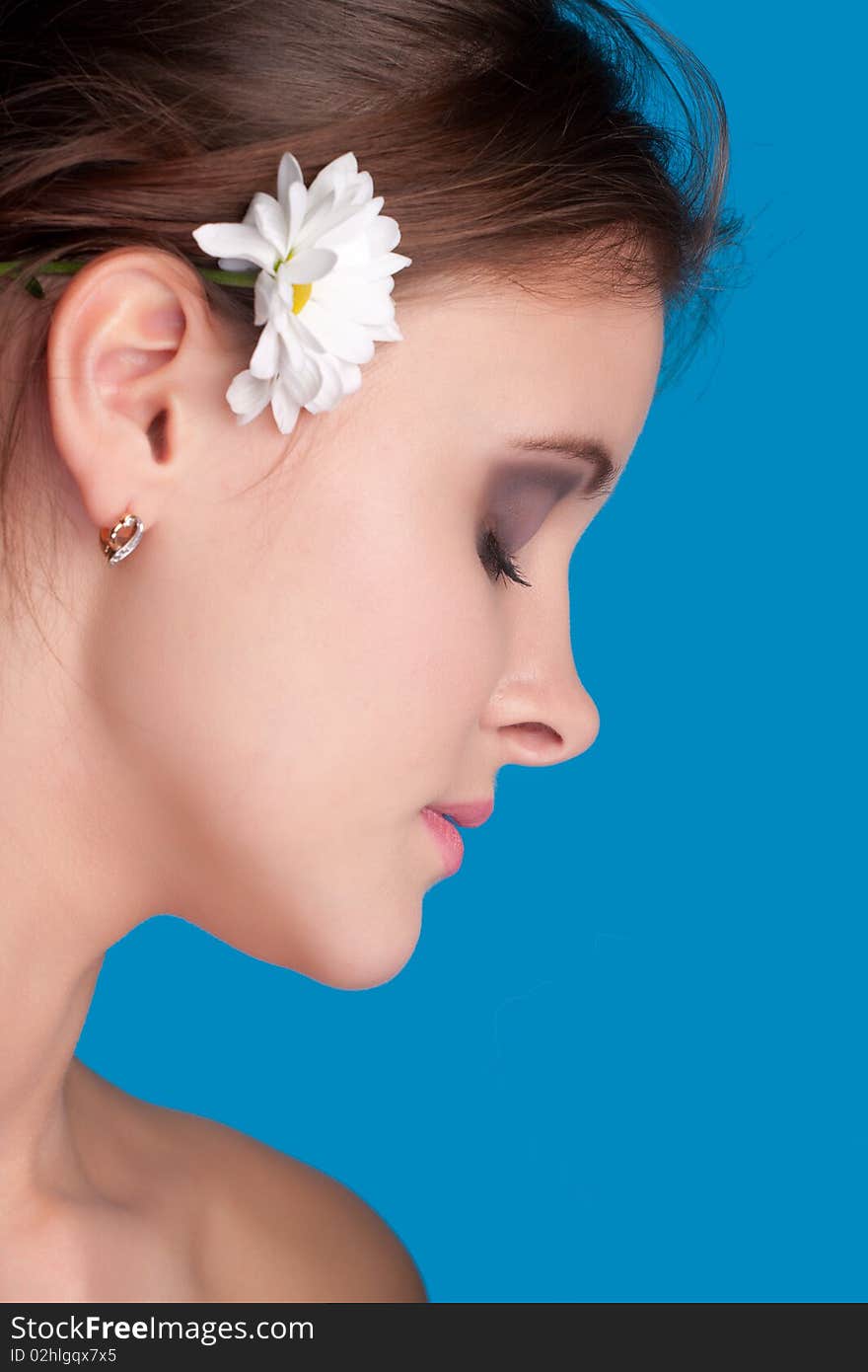 Close-up beautiful fresh young brunette smiling in studio shot with camomile. Close-up beautiful fresh young brunette smiling in studio shot with camomile