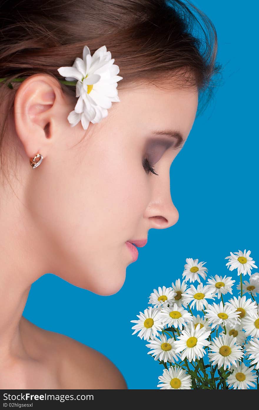 Close-up beautiful fresh young brunette smiling in studio shot with camomile. Close-up beautiful fresh young brunette smiling in studio shot with camomile