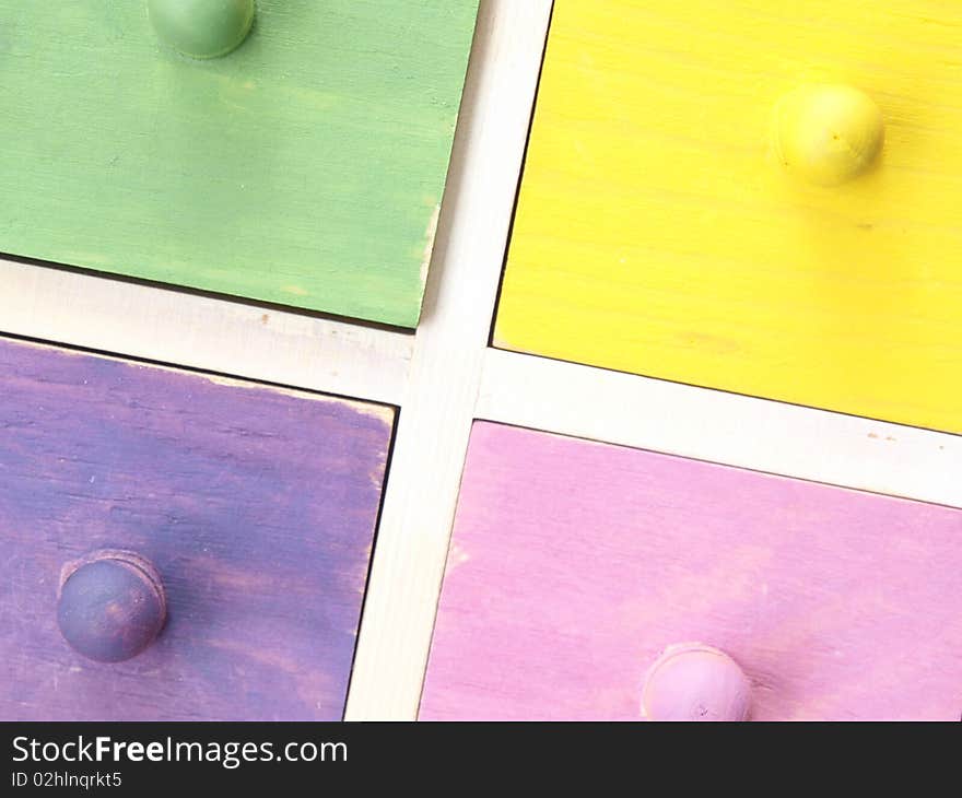 Colourful wooden drawers in yellow and pink and green and purple. Colourful wooden drawers in yellow and pink and green and purple