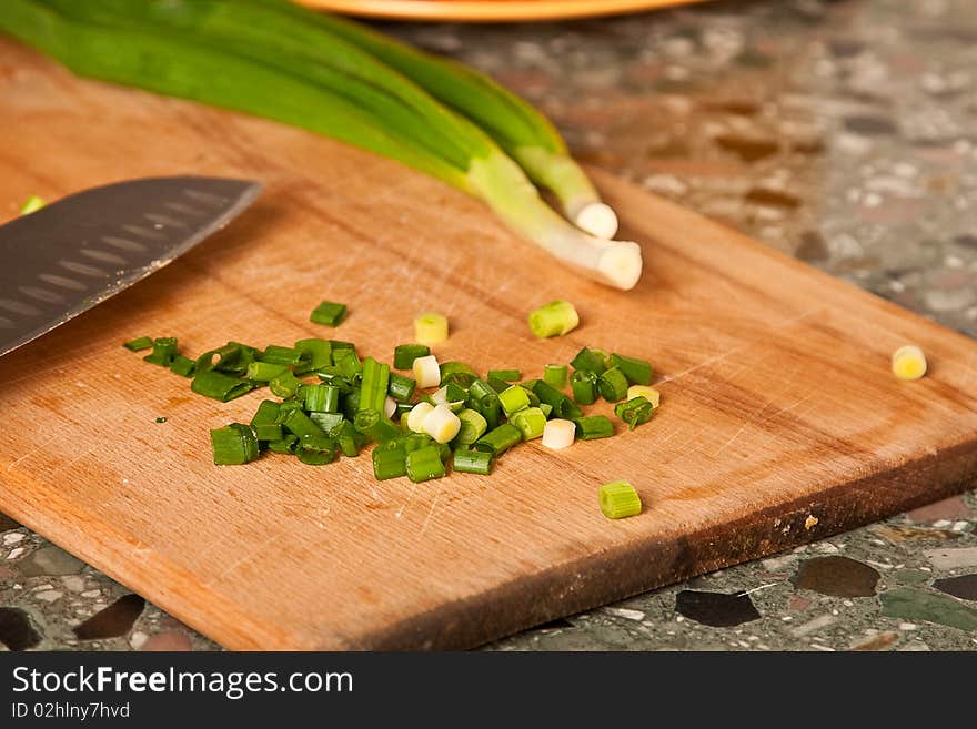 Sliced green onion on a wooden board