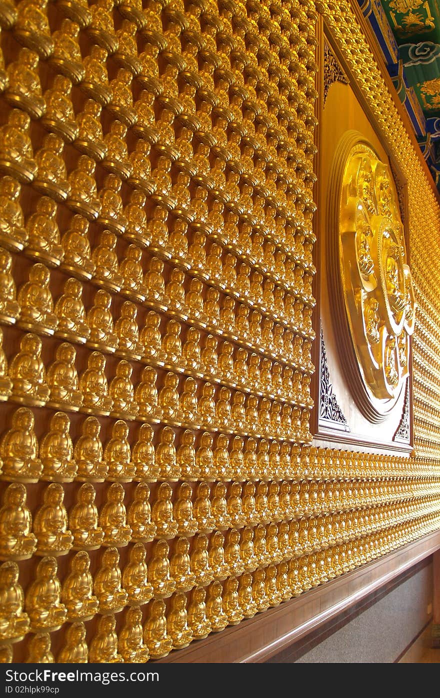 A lot of gold buddha statue stick on the wall