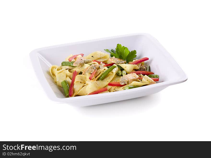 Pasta with salmon in bowl on white ground