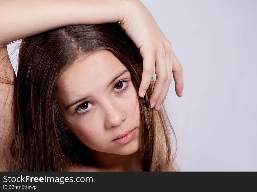 Portrait of young girl put hand on head on gray background