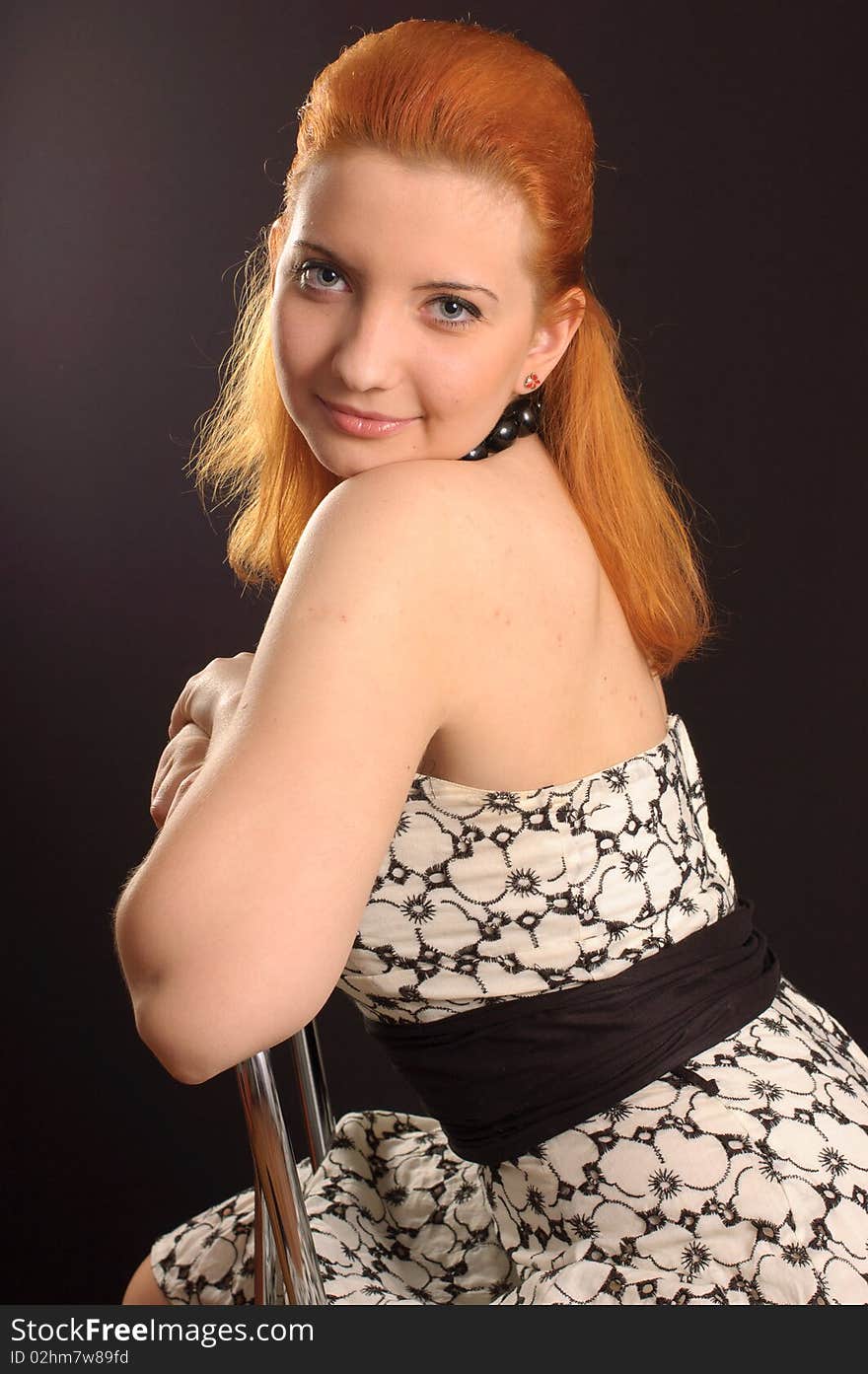 Red-haired woman in a dress in a retro style on a black background