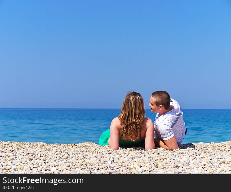 Two young people repose on sea beach. Two young people repose on sea beach