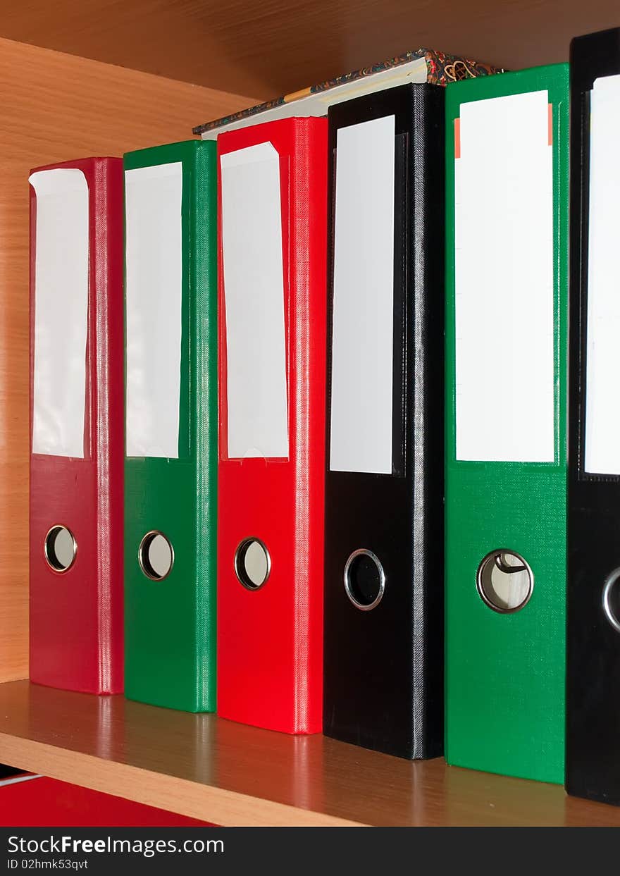 Colored accountant folders in the wooden bookshelf