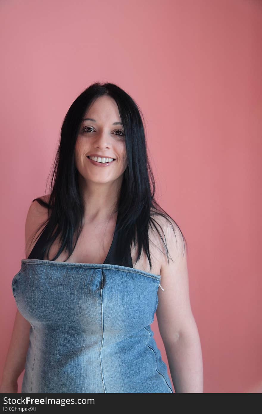 Smiling girl dressed in her jeans behind a pink background. Smiling girl dressed in her jeans behind a pink background