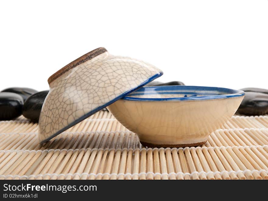 Two Tea Clay Cups And Stones On Mat