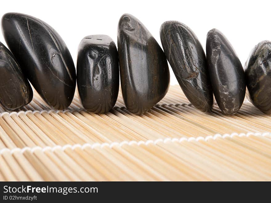 Number of dark stones lies on mat isolated in white