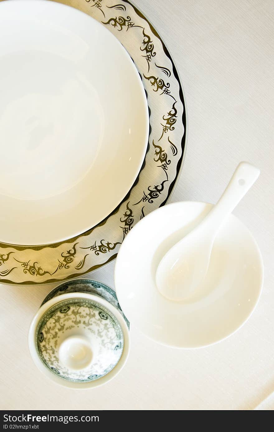 The tableware of china, plate and cup , bowl, spoon, on white. The tableware of china, plate and cup , bowl, spoon, on white