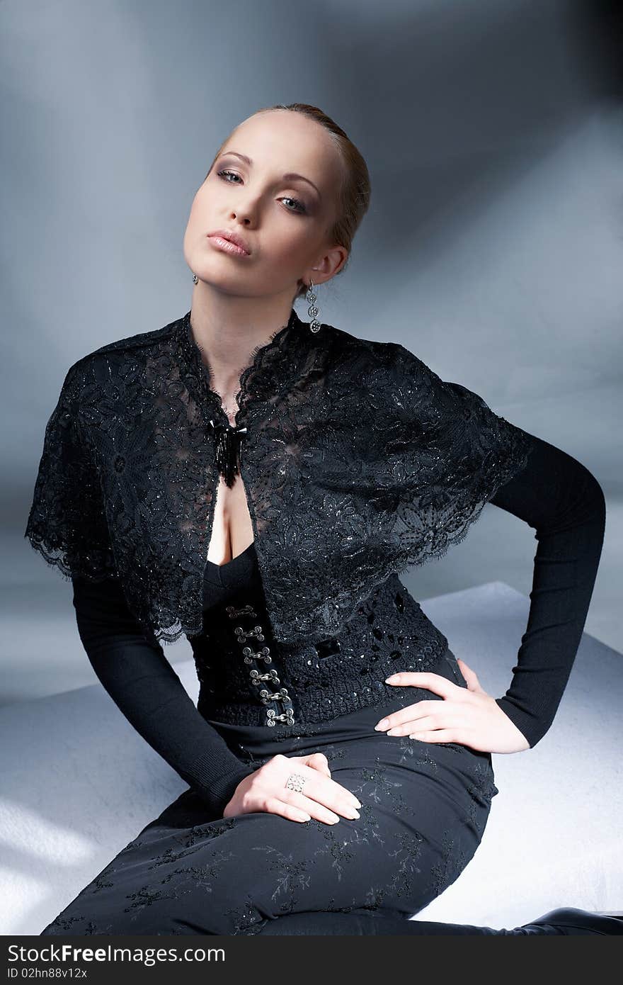 Beautiful blond model sitting and posing in the black vintage clothes. Beautiful blond model sitting and posing in the black vintage clothes.