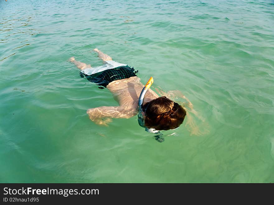 Young boy likes to snorkel in the clear water at the beautiful beach. Young boy likes to snorkel in the clear water at the beautiful beach