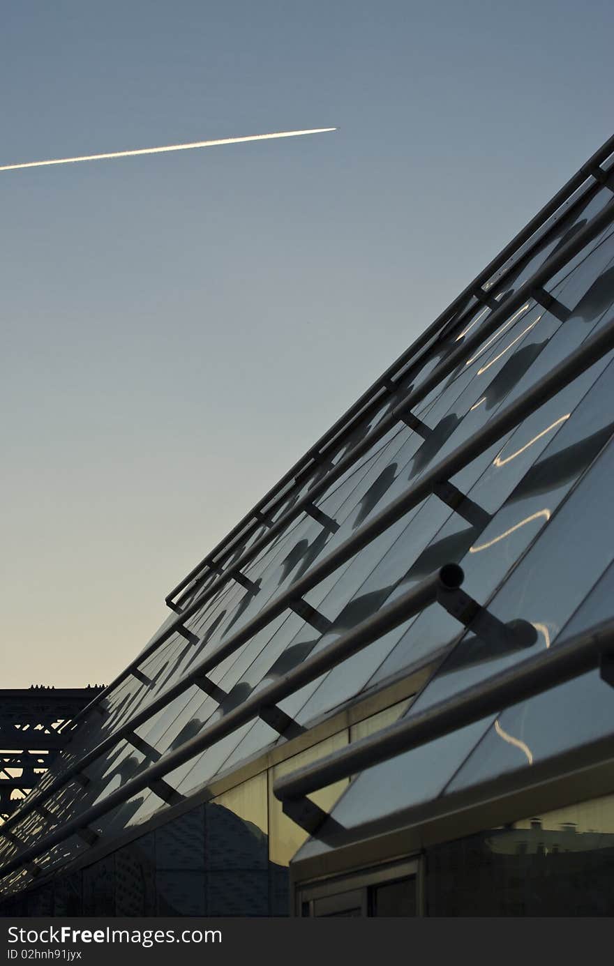 Glass roof panels, aircraft trace in the sky reflecting