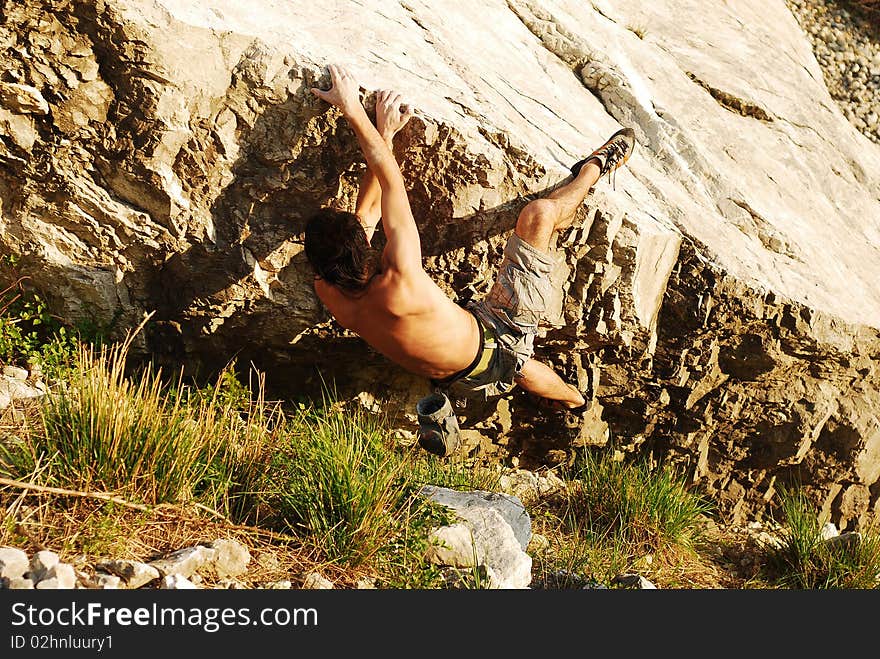 Climber trying to climb the edge of a boulder