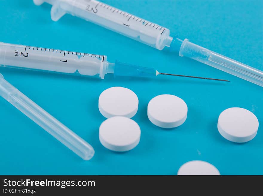 Tablets and syringes on a blue background