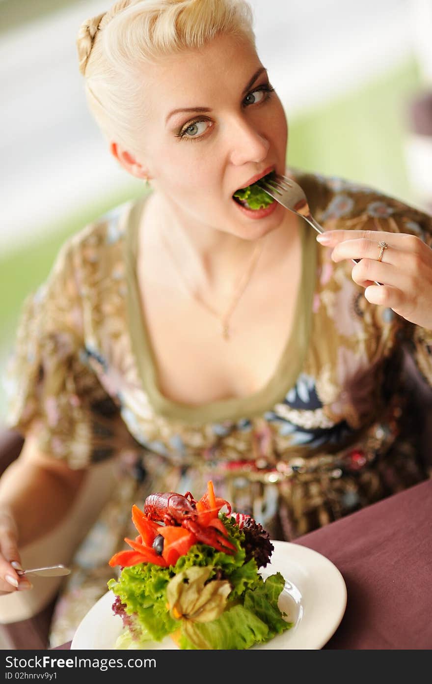 Beautiful woman eating salad in a restaurant