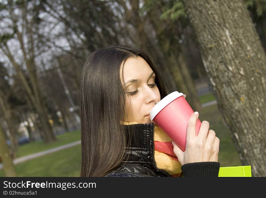 Beautiful elegant female strolling with documents and folders with a glass of hot coffee. Beautiful elegant female strolling with documents and folders with a glass of hot coffee