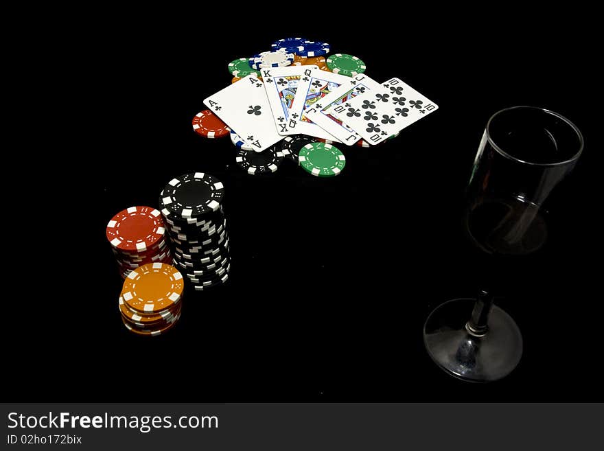 Royal flush, chips and glass of wine