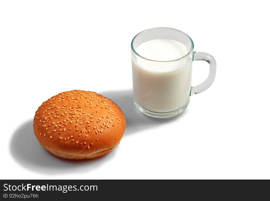 Glass of milk and bun on table