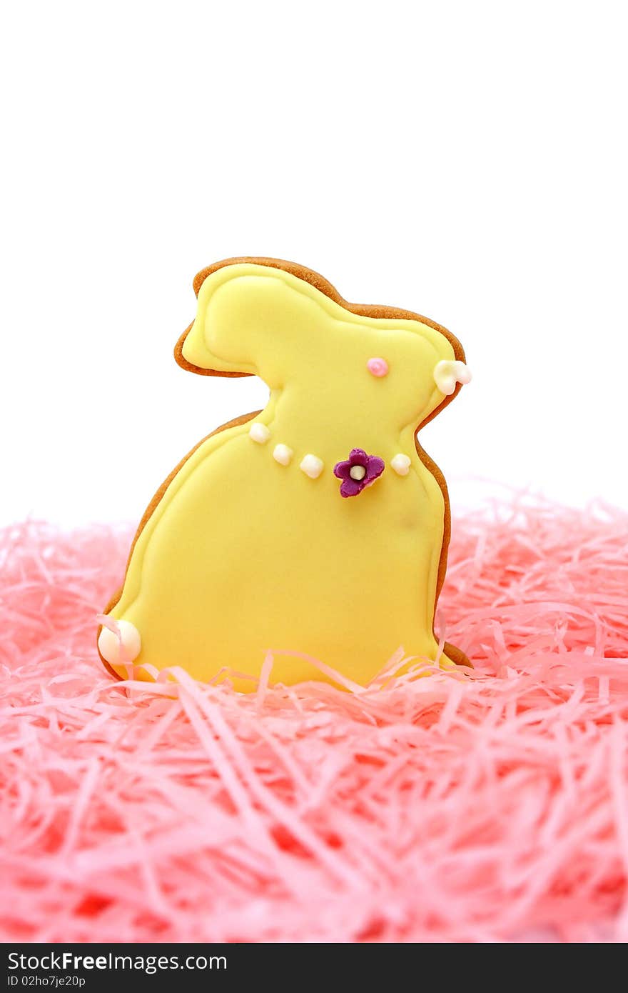 Close up of easter bunny cookies on pink ribbons over white background.