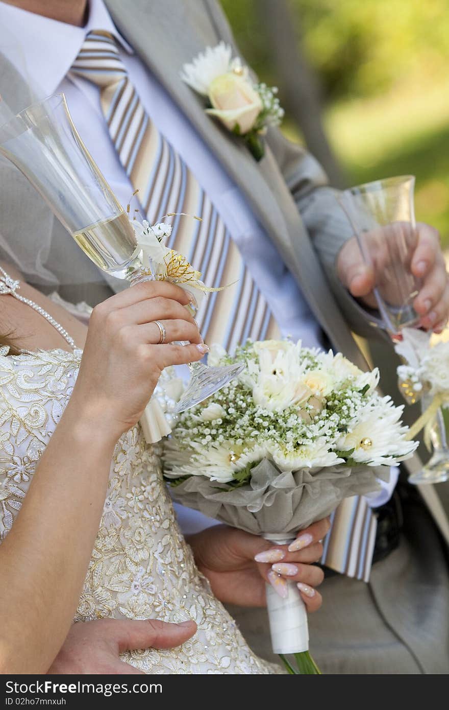 Bride and groom are holding champagne glasses