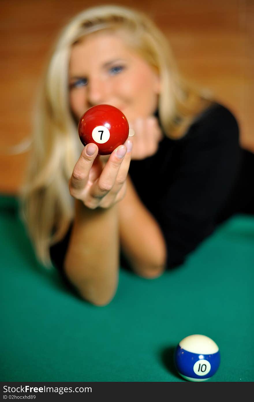 Beautiful woman holding a billiard ball. focus on the ball