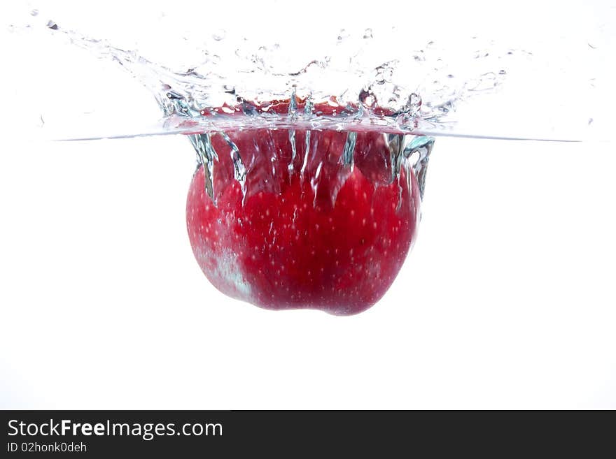 Red apple splashing into water