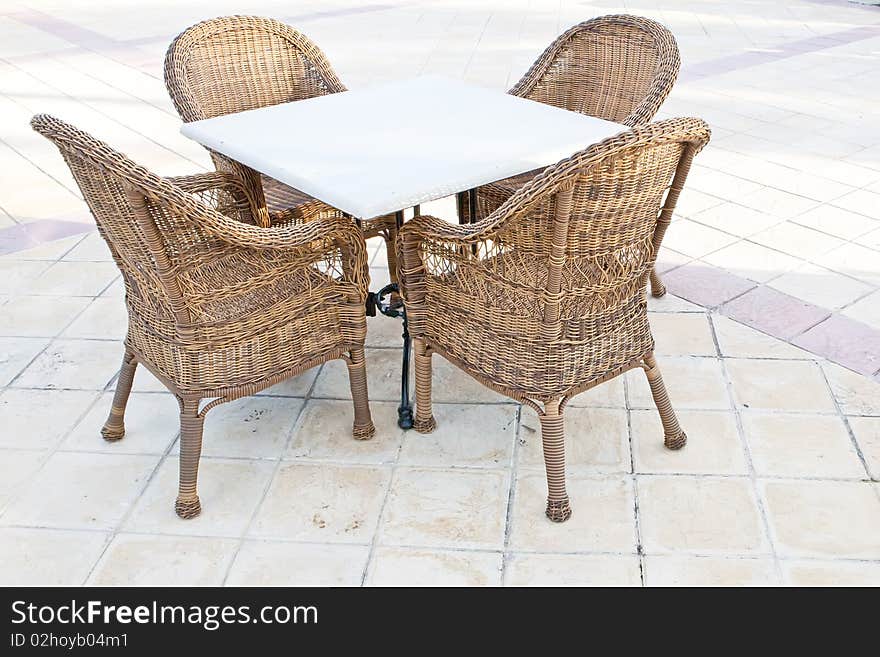 Brown wooden chairs an tables on patio in the morning