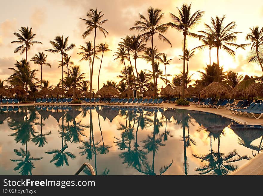 Blue and red sunset over sea beach with palms Dominican republic