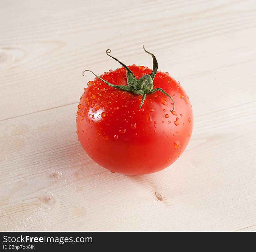 One fresh tomato in studio