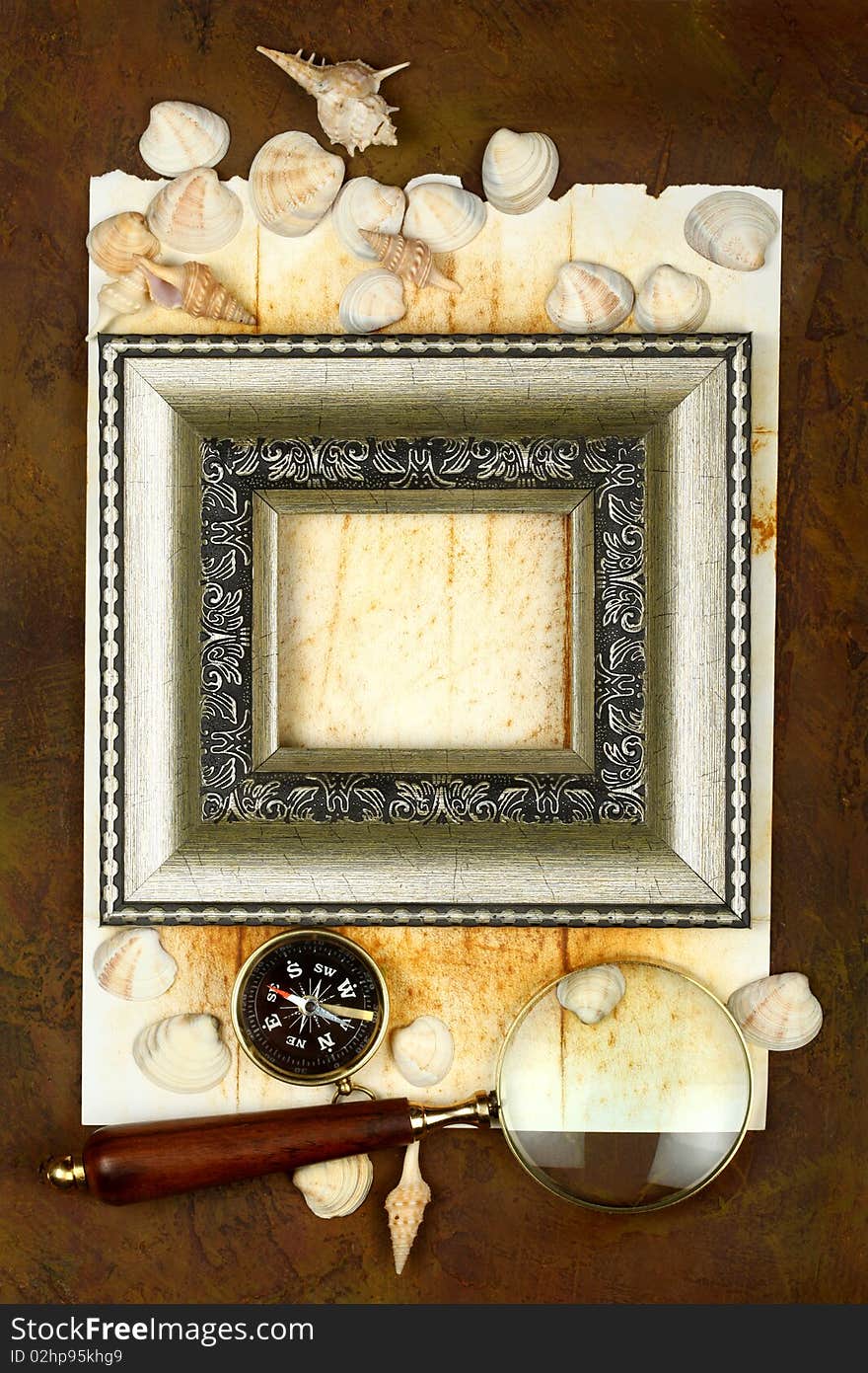 Antique frame with a compass, cockleshells and a magnifier