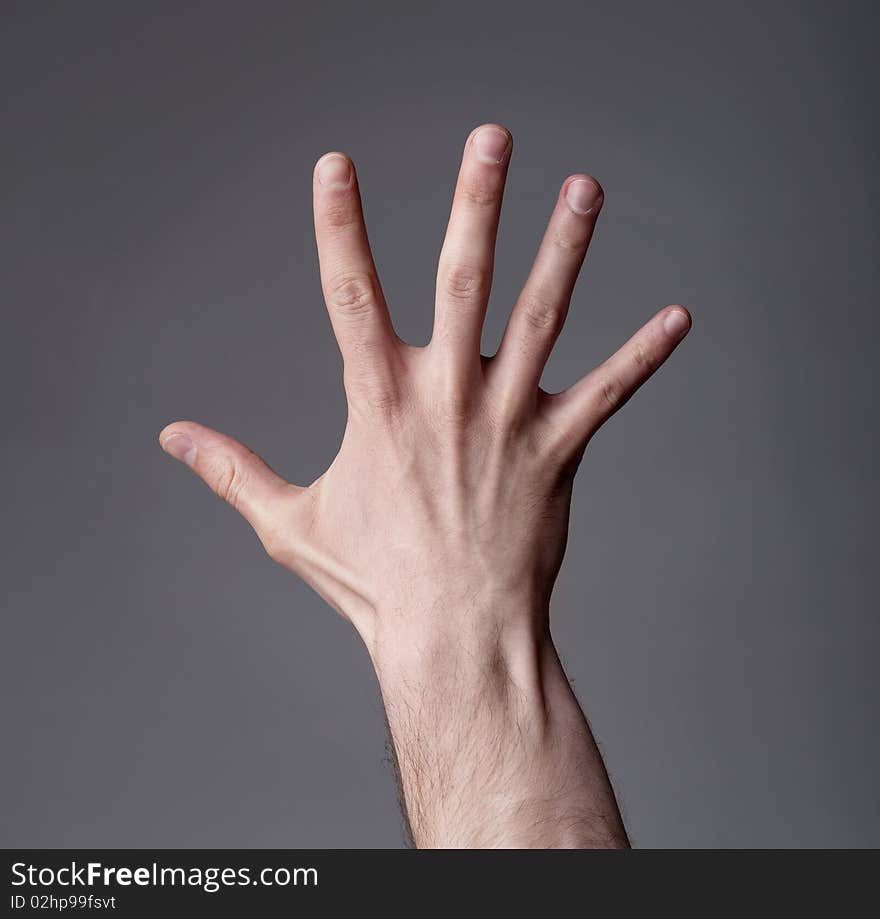 Hand showing finger up on grey background. Hand showing finger up on grey background