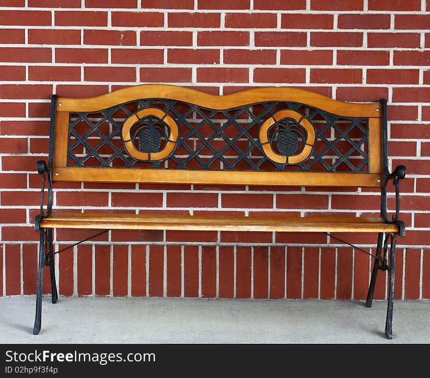 Wooden and metal bench against a brick wall. Wooden and metal bench against a brick wall