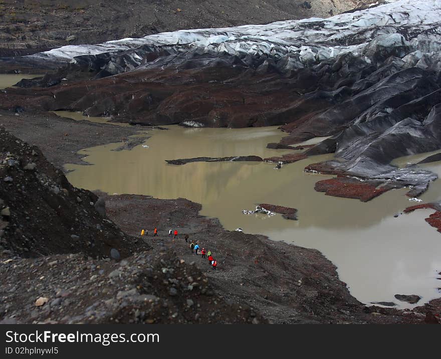 A group of people is walking to the Vatnajokull glacier. Southern Iceland. A group of people is walking to the Vatnajokull glacier. Southern Iceland